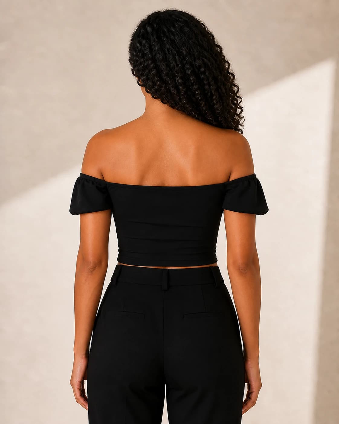 Top crop negro off shoulder frunce, vista de espalda en modelo