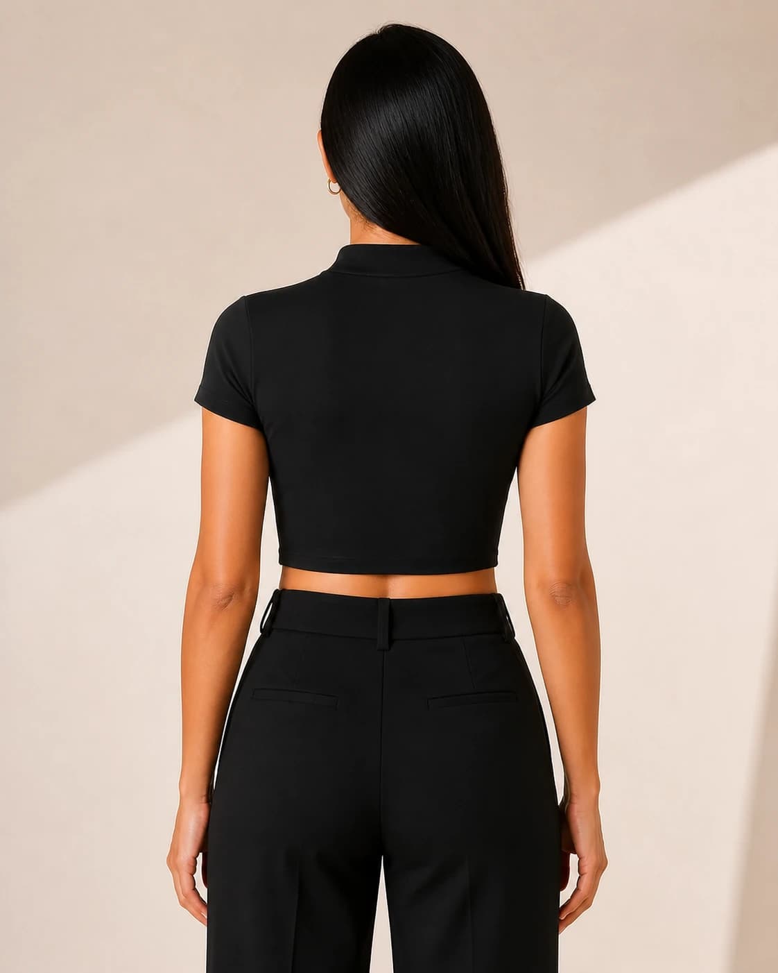 Top crop negro cuello alto, vista de espalda en modelo