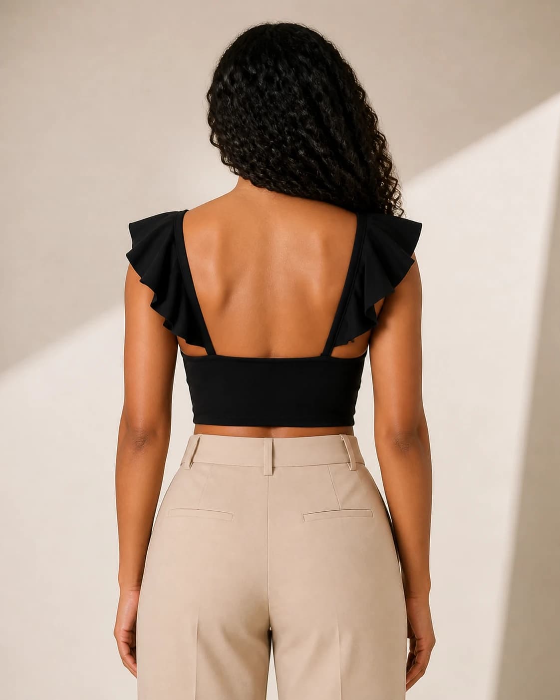 Top crop negro twist, vista de espalda en modelo