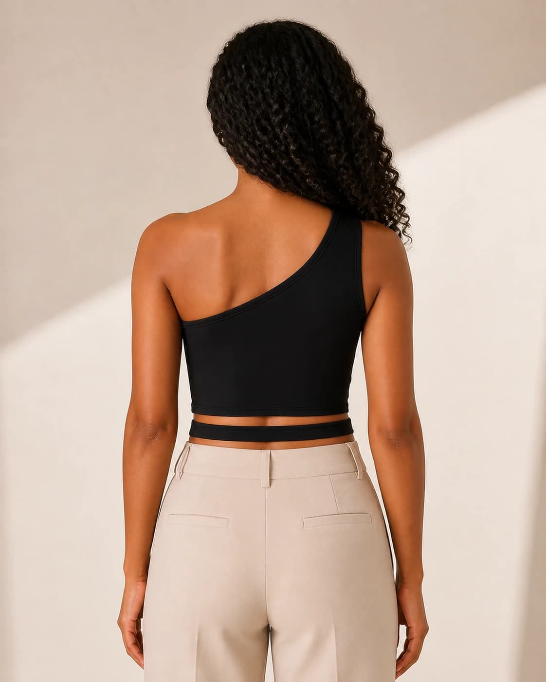 Top crop negro un hombro cutout, vista de espalda en modelo