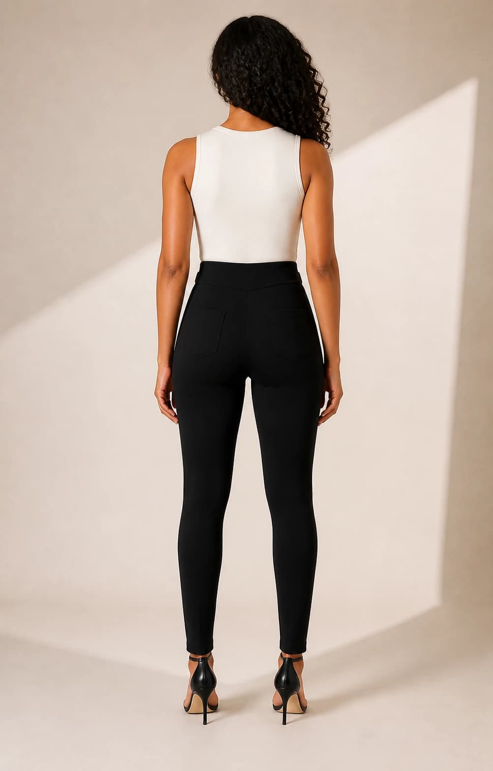Pantalon negro hebillas doradas, vista de espalda en modelo